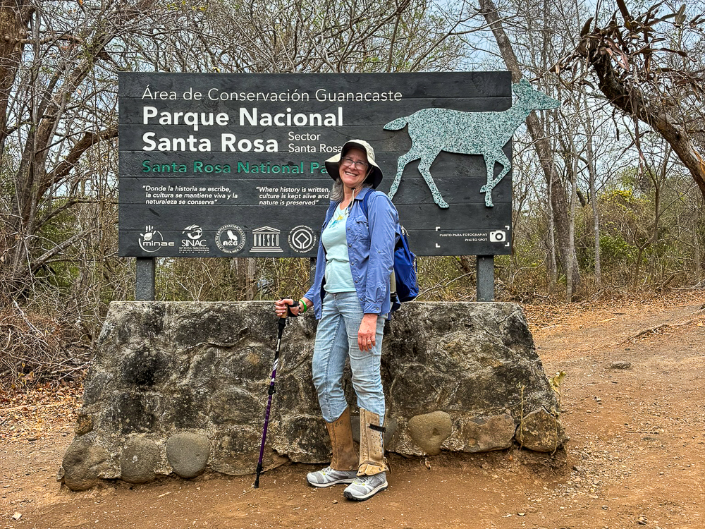 Person standing in front of the Santa Rosa National Park sign with a deer illustration.